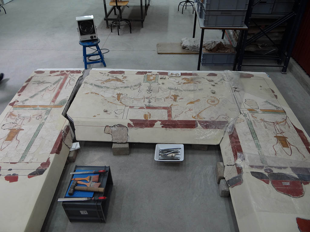 Detalle del proceso de restauración de la pintura de uno de los pórticos.